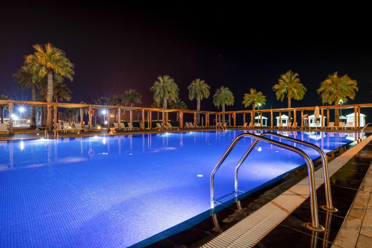 海岸线海滩穆尔瓦度假村 乌姆赛义德 外观 照片 A swimming pool at night