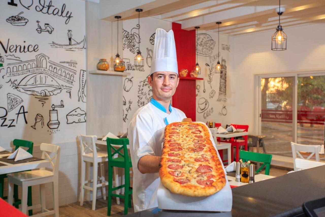 海岸线海滩穆尔瓦度假村 乌姆赛义德 外观 照片 A pizzaiolo with a metre-long pizza