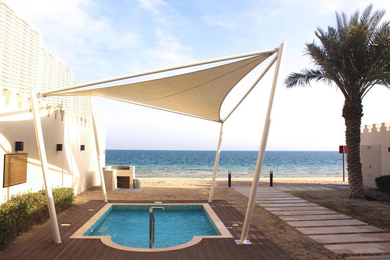 海岸线海滩穆尔瓦度假村 乌姆赛义德 外观 照片 A shade sail over a swimming pool